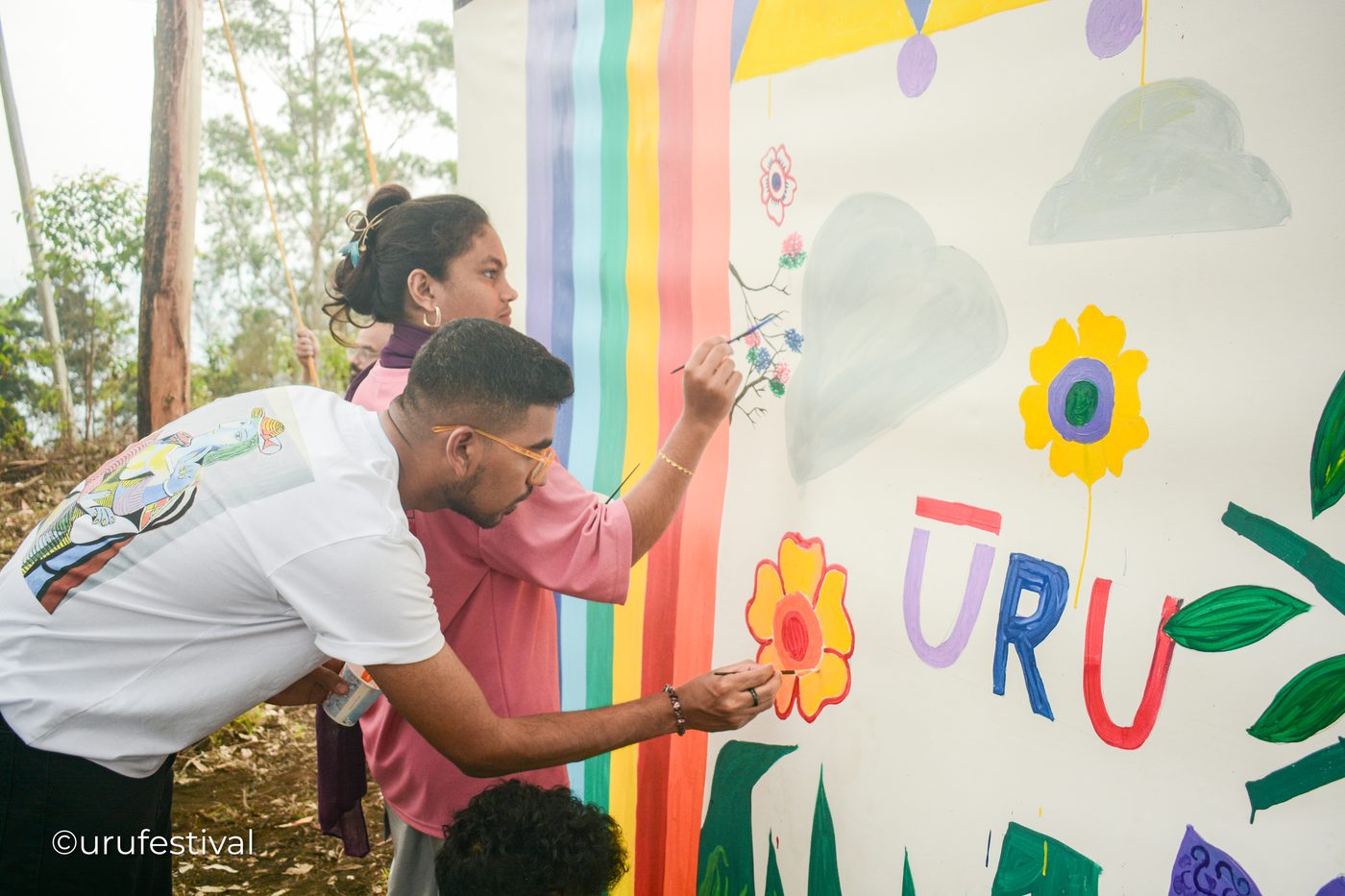 ŪRU attendees painting a collective mural with the ŪRU letters